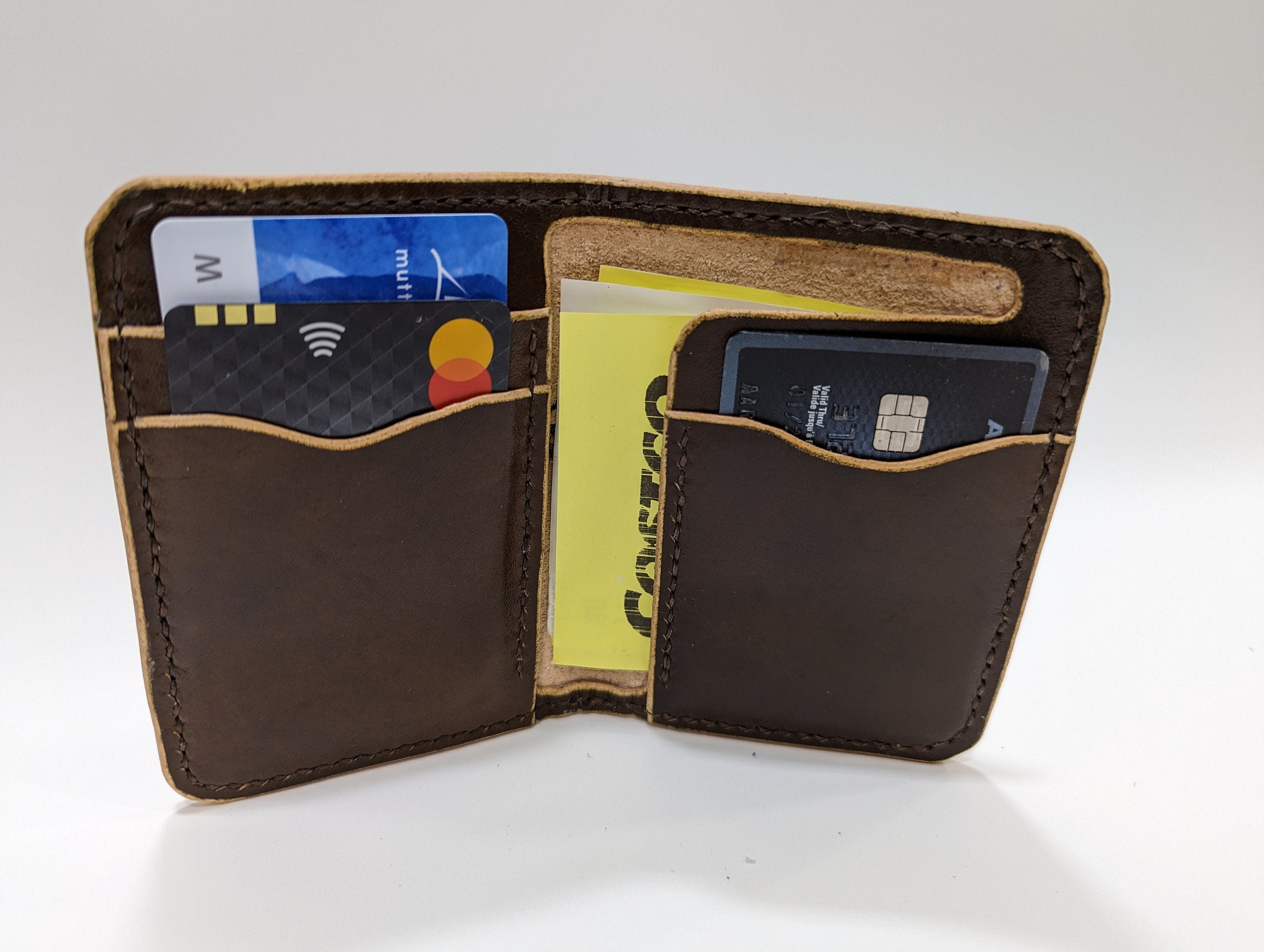 Brown leather wallet with cards and a cardholder on a white background