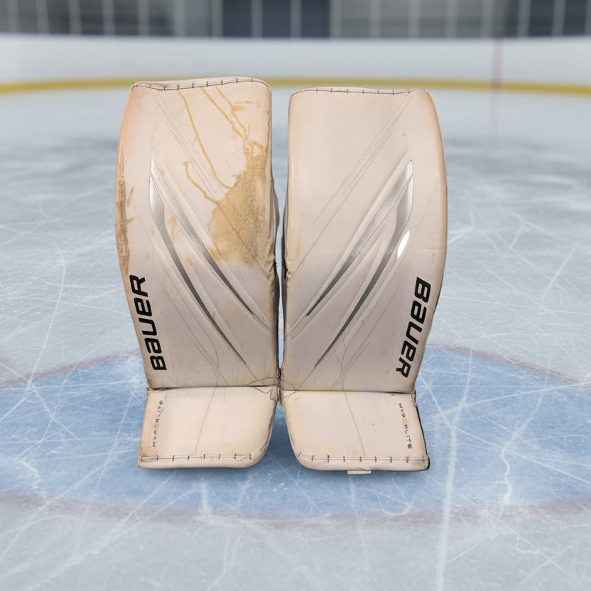 Pair of Bauer hockey goalie pads on an ice rink
